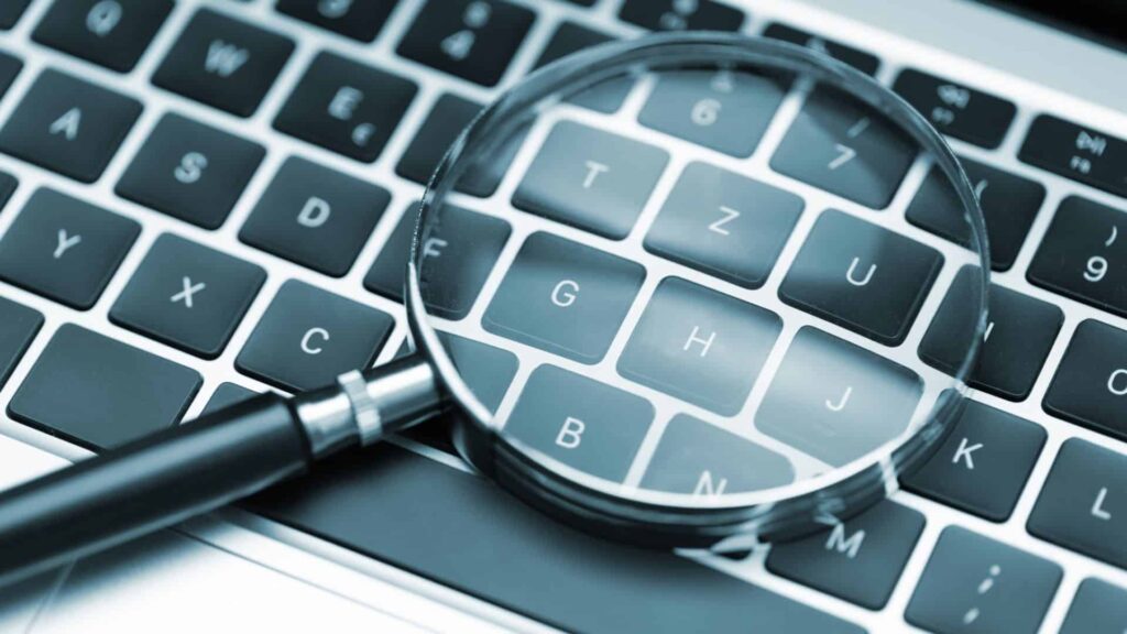 A magnifying glass on a laptop representing a SEO Audit