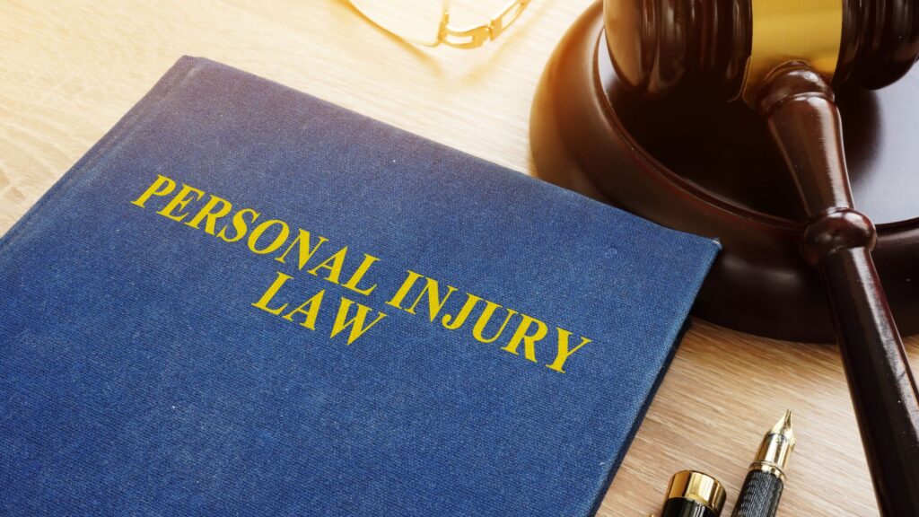 Personal injury law book next to a gavel on a lawyer's desk